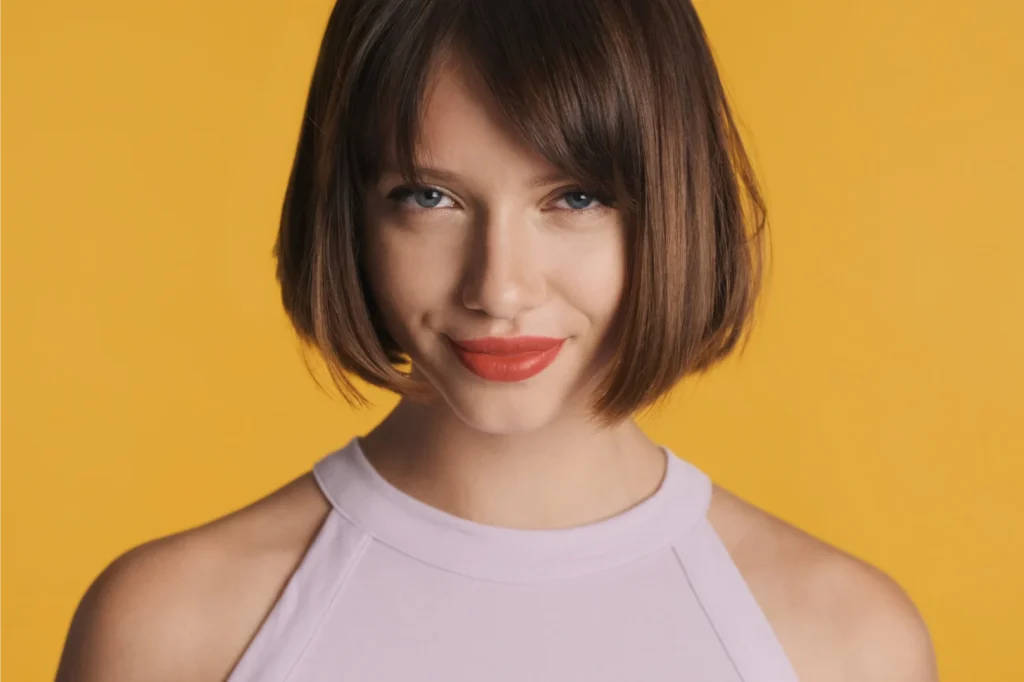 Woman with bob cut smirking.