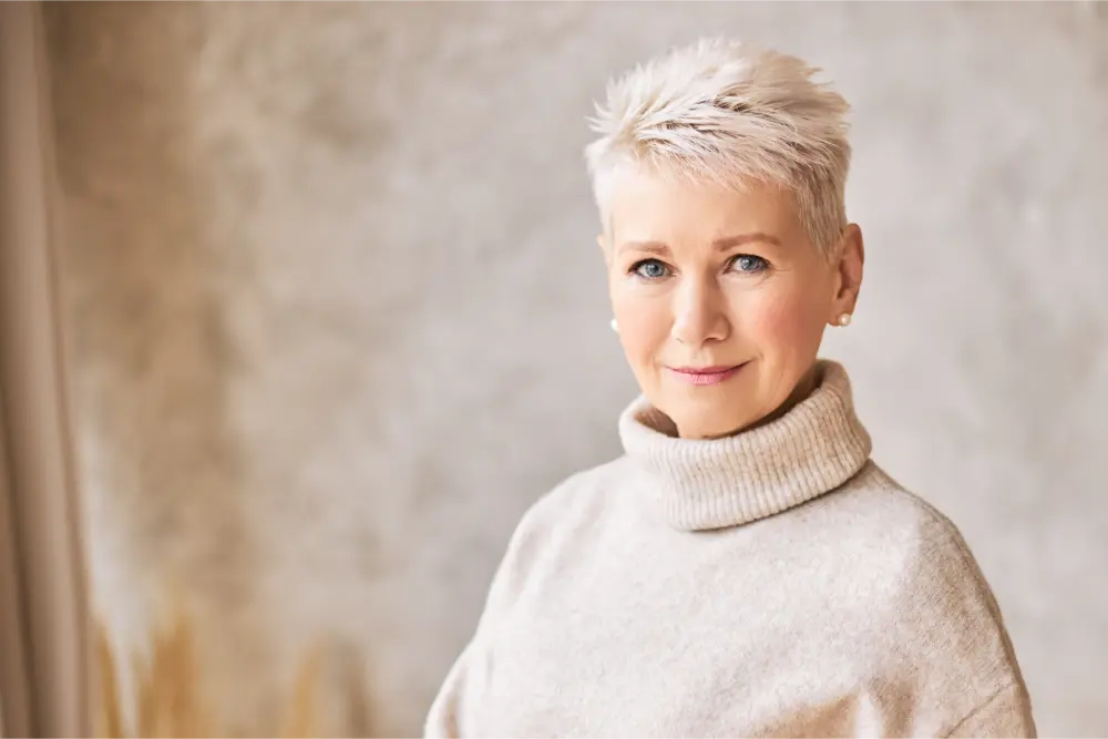 Woman with blonde hair in a beige turtleneck.